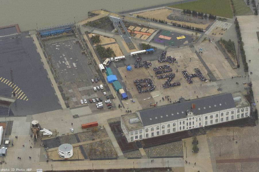 Au premier plan les bureaux des Ateliers et Chantiers de Bretagne. Renommés au fronton nord Ateliers et Chantiers de Nantes. À gauche des bureaux l'éléphant en promenade. Au fond la Loire et sur la gauche La Grande Cale. La fresque est devant la façade n