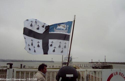 Drapeau de Saint-Nazaire. Un remorqueur accompagne le Campbeltown vers l'Estuaire.