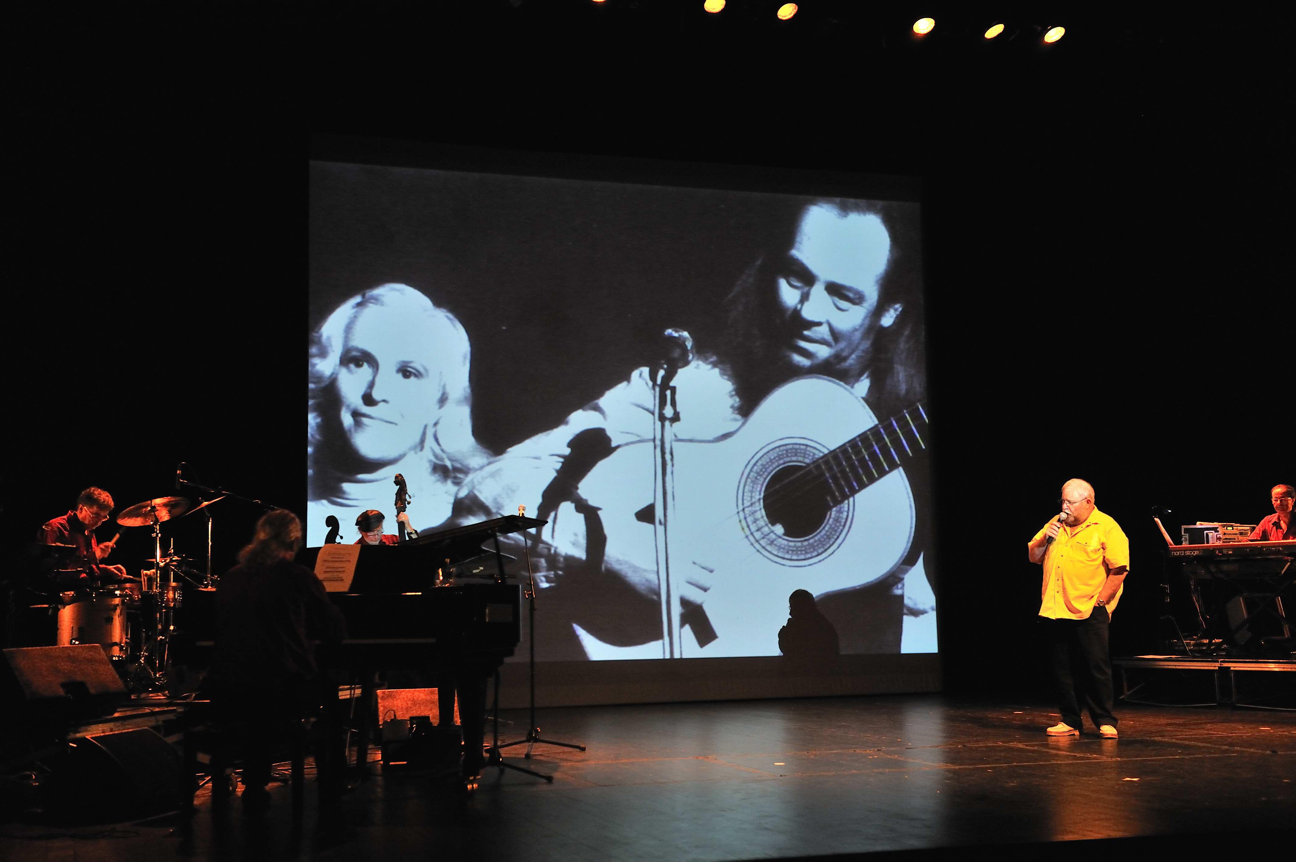 Yvon Étienne chante devant la photo de Glenmor et Katell.