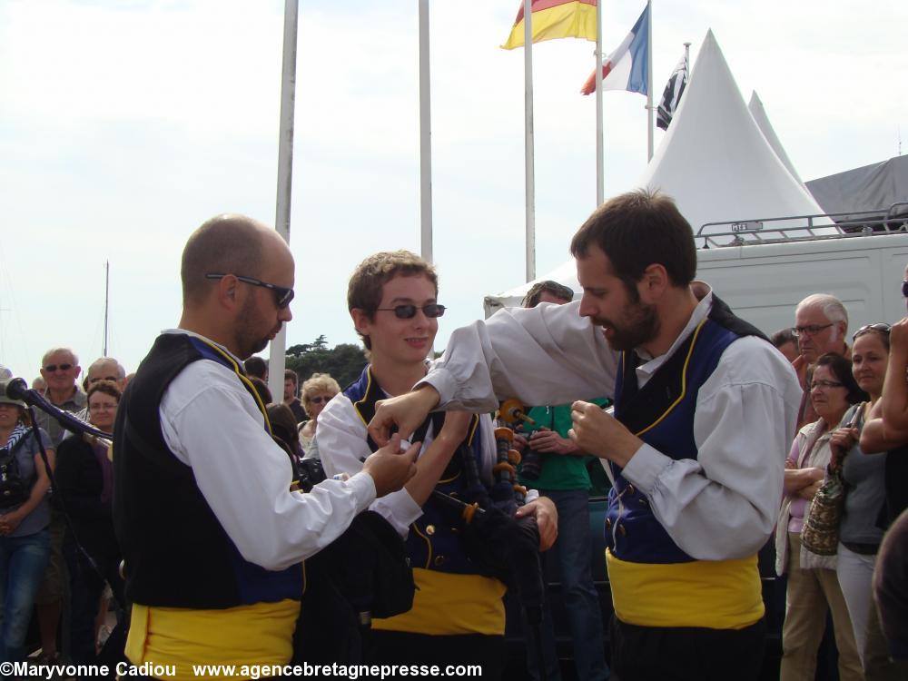 Derrière les stands le bagad de Landerneau “bricole” un bourdon. Le rouleau de ruban adhésif fait partie de la boîte à outil du sonneur. À droite Tangi Thomin (voir dans le texte). Fête bretonne de la Saint Gilles à Pornic 2012.