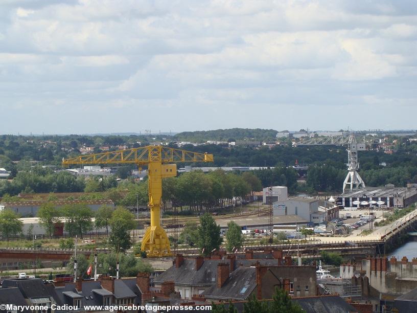 Les deux grues Titan. La jaune restée sur l’ancien site des Chantiers navals et la grise sauvée et des quais de déchargement/chargement du port déplacée à la Pointe de l’Île (anciennement) Sainte Anne quai Wilson. Devant la grue grise le fameux « Hangar à bananes » face nord sur le quai des Antilles.