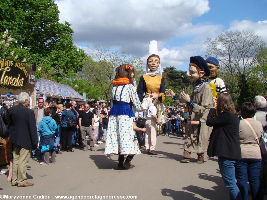 En fin de parade un groupe de marionnettes sur échasses.