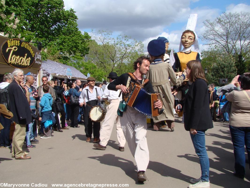 Un groupe de marionnettes sur échasses en fin de parade et en musique.