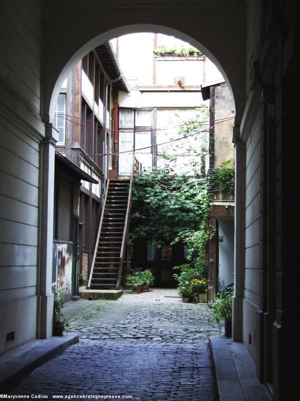 La Mission bretonne à Paris. Porche et cour. La Mission est au fond sous la verdure.