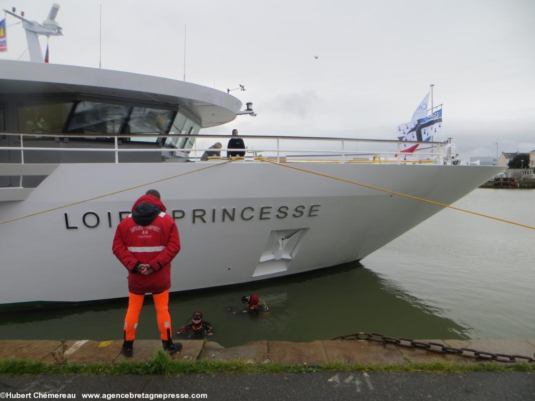 Avant la première croisière les pompiers plongeurs inspectent la coque du Loire Princesse dans le Bassin de Saint-Nazaire.