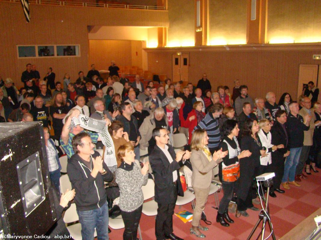 La salle applaudit Gilles Denigot après son discours de 30 minutes en fin de soirée.