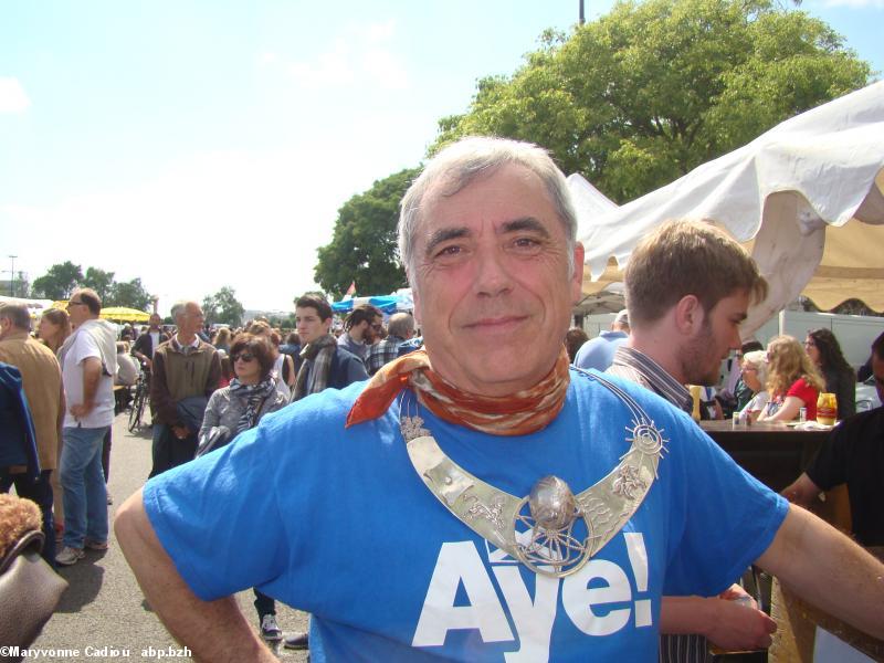 Le Grand druide a gardé son collier en argent - oeuvre d'un orfèvre belge amoureux de la Bretagne (maintenant décédé : Dominique Lefevre) - a retiré sa saie et porte un tee-shirt d'Écosse. Tablée bretonne Nantes 2016. 