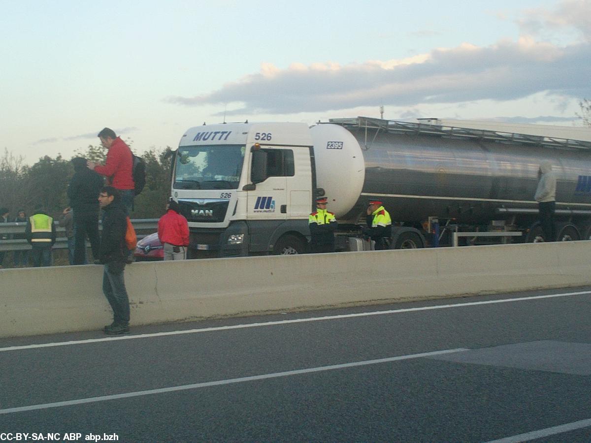 Deux policiers catalans (Mossos) séparent les files de camions des manifestants