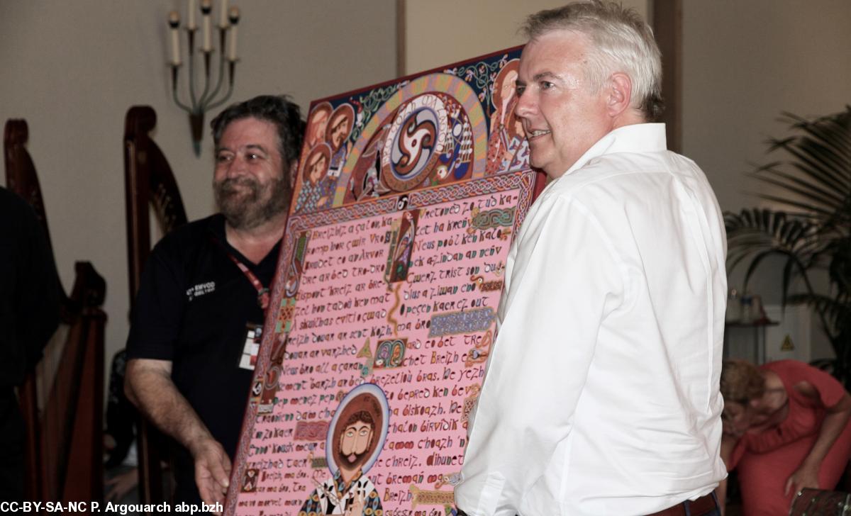 Lisardo Lombardía, directeur du FIL, remet au Premier ministre du Pays de Galles Carwyn Jones, un mandala confectionné par un Breton vivant aux Indes. Le poster représente les liens historiques entre le Pays de Galles et la Bretagne.