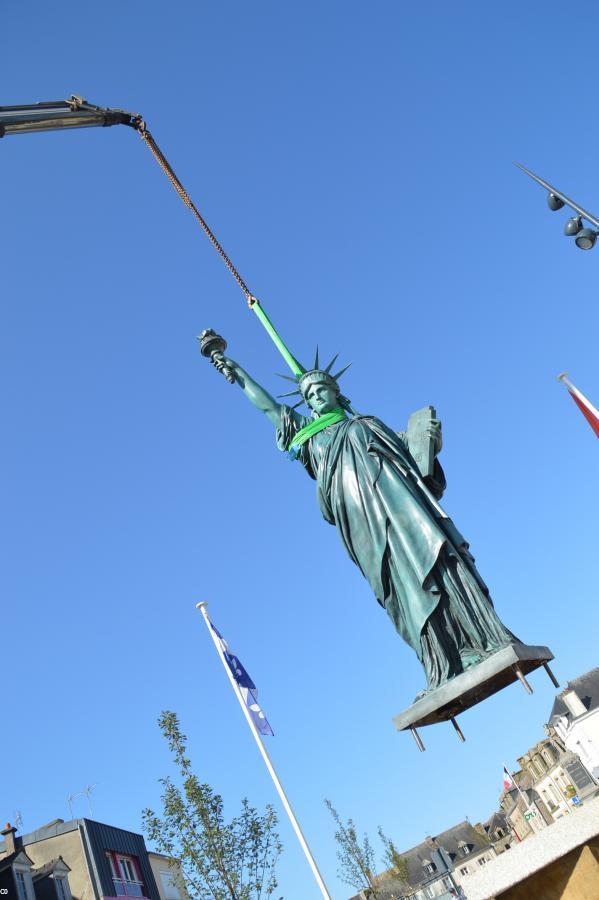 La statue, allégorie de l'émigration bretonne vers les Amériques a été transporté par les airs jusqu'à son piedestal.