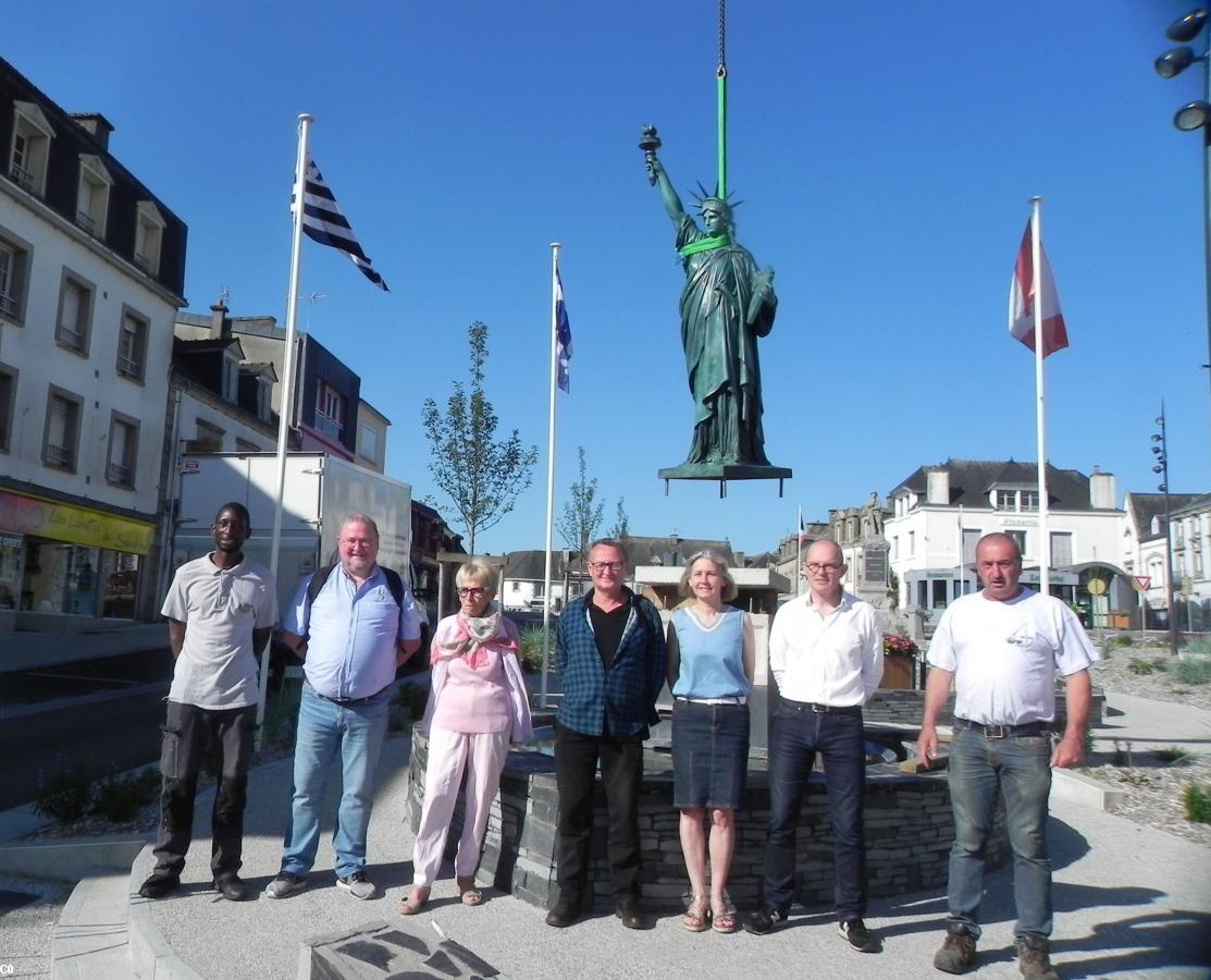 De gauche à droite: le transporteur, l'équipe de Bretagne Transamerica Jean-François Baudet, Christiane Jamet, Pierre-Marie Quesseveur, l'équipe municipale Catherine Henri, David Le Solliec et le grutier.