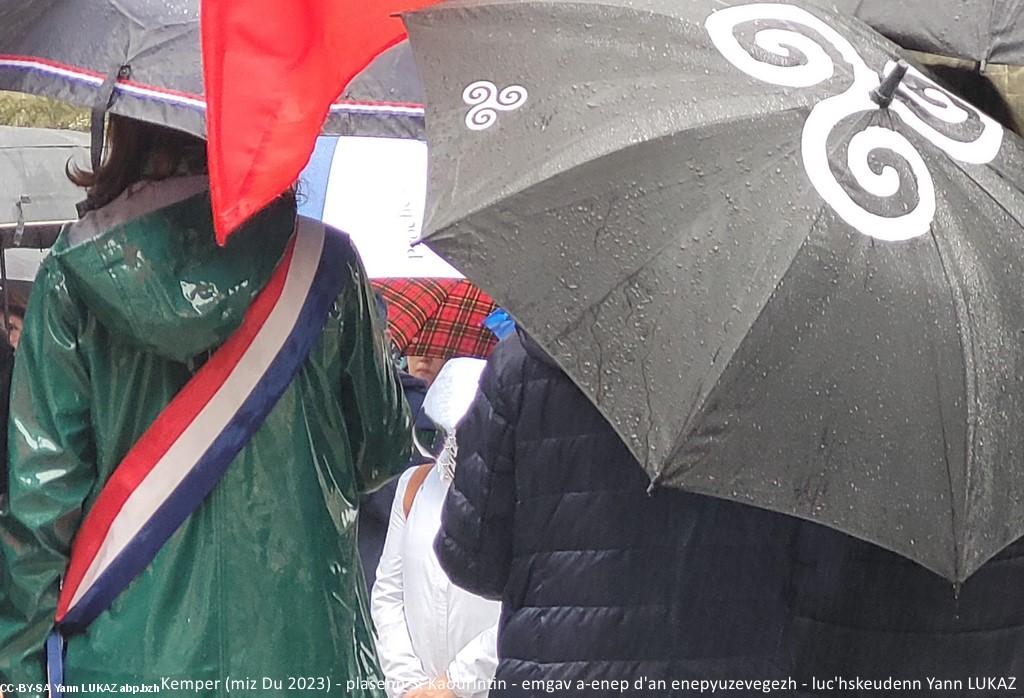 Dindan ar glav-puilh, e-tal da ti-kêr Kemper ha tostik diouzh an Iliz-veur. Prezegenn ar vaerez. Sous une pluie insistante, depuis le perron de la mairie, à proximité immédiate de la Cathédrale Saint Corentin. Prise de parole de Mme la Maire.